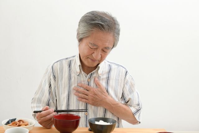吐き気を感じる男性